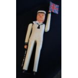 Naive wooden painted model of a sailor with reticulated arms, holding a Union Jack flag. Height