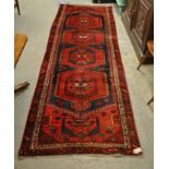 Red ground Persian runner with medallion designs. 282 x 95cm approx. (B.P. 21% + VAT)