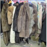 Two fur coats in dark grey and dark brown and three fur stoles including two different colours of