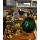 Tray with brass oil burner with glass chimney, two brass candlesticks and a large green glass