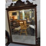 Edwardian mahogany framed over mantel mirror with foliate carved arch pediment and bevelled plate.