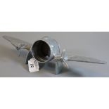 Unusual aluminium table clock case in the form of a twin engined aircraft. Lacks clock. (B.P.