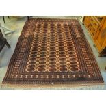 Middle Eastern design pink and red ground carpet with central guls and stylised decoration. (B.P.