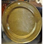 Large Middle Eastern design brass charger with raised floral and other decoration. (B.P. 21% + VAT)