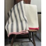 Two antique narrow loom Welsh woollen blankets; one with a wide black stripe and the other a plain