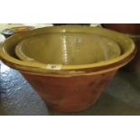Two matching, graduated, glazed and earthenware crochanau or dairy pans, terracotta with yellow