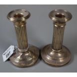 A pair of silver Corinthian column candlesticks with loaded bases, Birmingham hallmarks. (B.P. 21% +