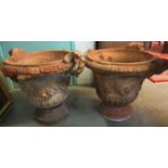 Pair of terracotta campana shaped urns with leaf and mask mounts, the bodies relief decorated with