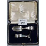 Cased silver two-piece Christening set with pierced spiritual swastika decoration. London hallmarks.