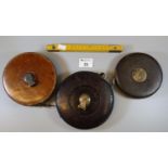 Three vintage leather cased tape measures and a one meter folding ruler. (B.P. 21% + VAT)