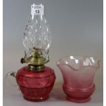 Early 20th century single chamber oil burner, with glass chimney and cranberry glass reservoir,