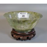 A jade like oriental style bowl on hardwood stand. (B.P. 21% + VAT)