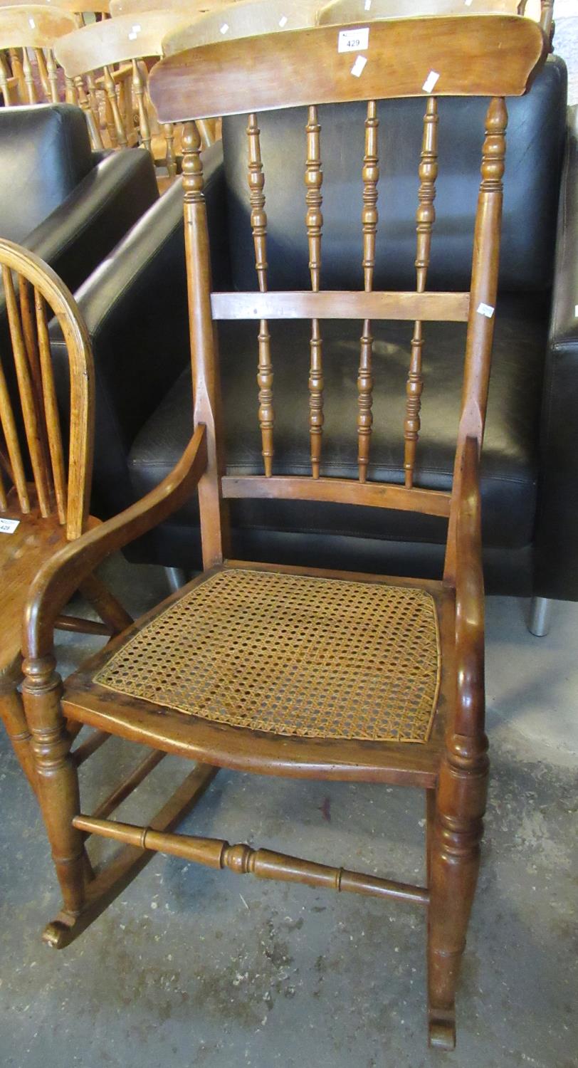 20th Century beech spindle back rocking armchair on cane seat. (B.P. 21% + VAT)