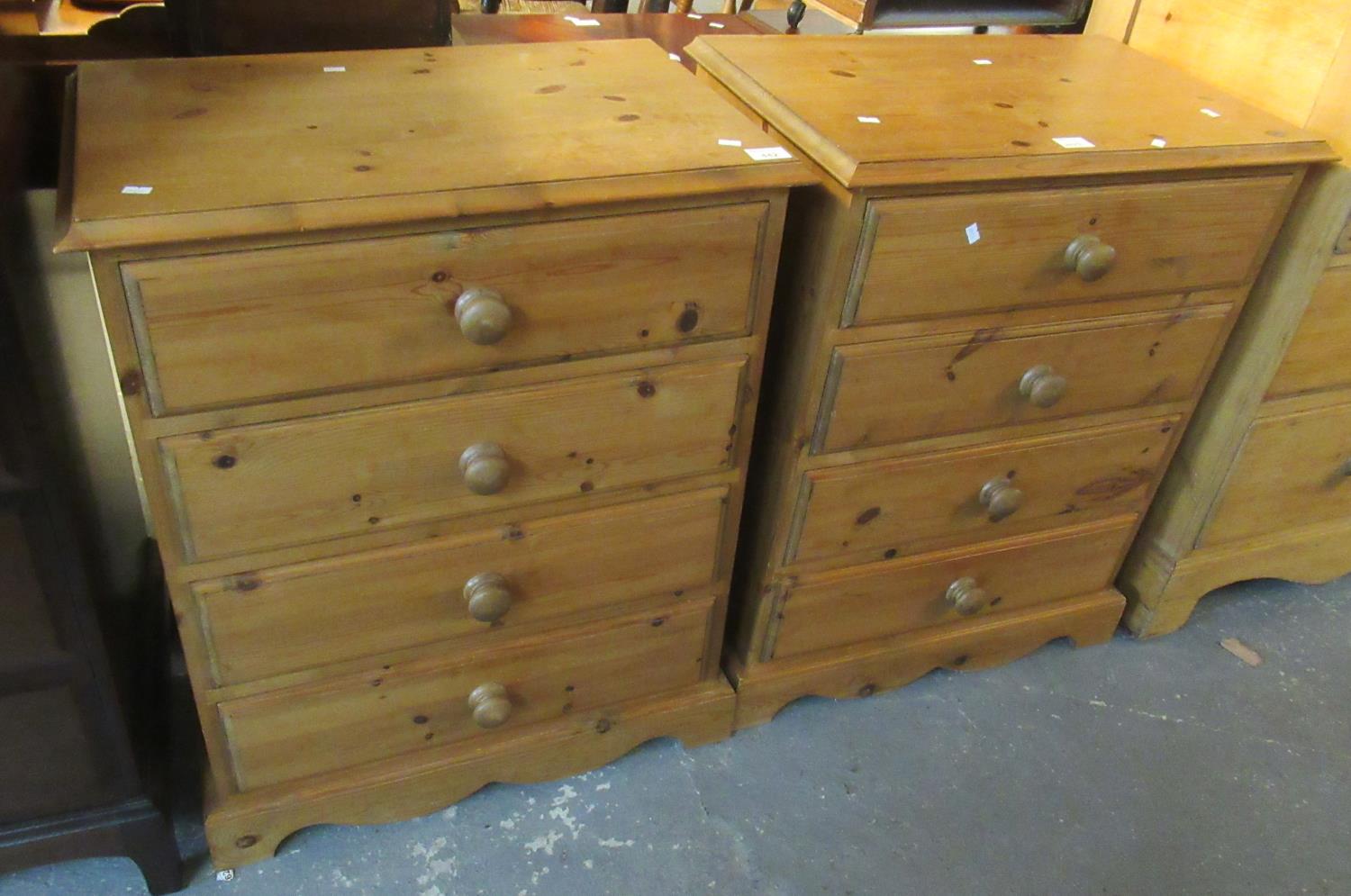 A pair of modern pine straight front chests of four drawers with turned handles on a projecting