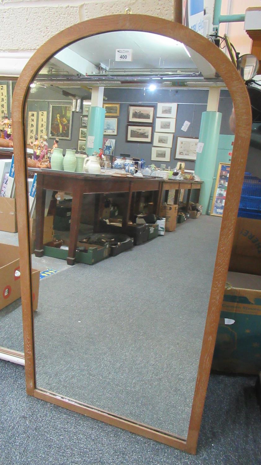 Two modern mirrors, one with an oak frame and dome top, the other painted of rectangular form. (