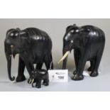 Two ebony carved elephants and their young calf. (3) (B.P. 21% + VAT)