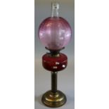 Early 20th Century double oil burner, having globular cranberry etched shade above a cranberry glass