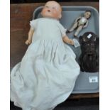20th century bisque headed doll with rolling eyes and painted features, together with a miniature