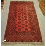 Middle Eastern design red ground runner or rug having central geometric guls and foliate banding.