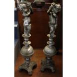 Pair of heavy cast iron firedog supports decorated with cherubs on a quatreform concave base and