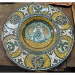 Large pottery charger decorated centrally with an angel and surrounded by floral decoration. (B.P.