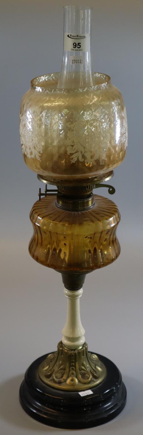 Early 20th Century double oil burner having orange shade, coloured reservoir on a ceramic brass