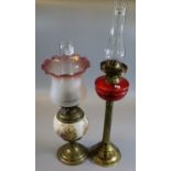 Early 20th Century double oil burner having glass chimney, cranberry glass reservoir on a brass