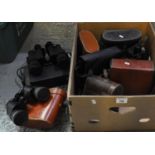 A box containing eight pairs of binoculars, most with their cases, including: Prinz 10 x 50,