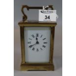 Early 20th Century brass carriage clock, unmarked with white face and black Roman numerals, having