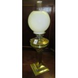 Early 20th century single oil burner with globular opaline glass shade above a brass reservoir and