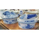 Two blue and white oriental design lidded casseroles with animal finials, one with goldfish and