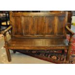 19th Century Welsh oak settle having five moulded panels to the back with open arms, the moulded