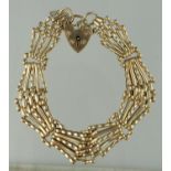 9ct gold five bar fancy link gate bracelet with safety chain and heart shaped padlock clasp.