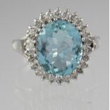 Aquamarine and diamond ring set in white metal. The oval aquamarine surrounded by diamonds in a