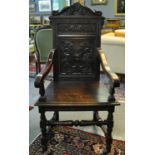 Late 19th/early 20th Century oak high back elbow chair with relief foliate and mask head carving,