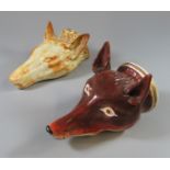 Two pottery/porcelain fox mask stirrup cups of different colour ways. 12cm long approx. (2) (B.P.