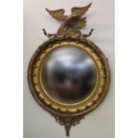Regency gilt framed circular convex pier glass, the gilded gesso frame surmounted by a carved