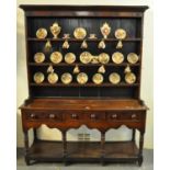Early 19th Century Welsh oak two stage rack back pot board dresser, the moulded cornice above