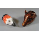 Two probably Staffordshire pottery/porcelain stirrup cups, one treacle glazed in the form of a foxes