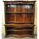 Victorian rosewood serpentine two stage open bookcase with carved and moulded flower heads and other
