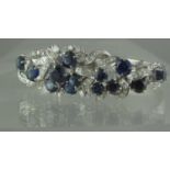 18ct white gold cocktail bracelet set with diamonds and synthetic sapphires. Approx weight 21 grams.