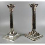 Pair of silver Corinthian column candlesticks on square stepped bases, rubbed hallmarks for