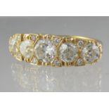 18ct gold five stone ring. The five graduated diamonds separated by diamond points in scroll