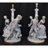 A large pair of Spanish porcelain table lamps modelled as 18th Century figures in fitted dress on