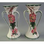 Pair of Llanelly pottery waisted three handled vases decorated with wild roses in the manner of