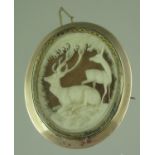Carved brooch depicting a stag and a foal in a woodland landscape set within a 9ct gold frame.