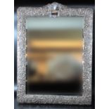 Silver repousse framed rectangular hanging wall mirror with arched cresting having vacant cartouche.