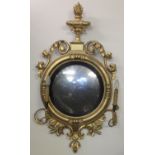 Regency period gilt gesso convex wall mirror with two sconces and flaming urn pediment, scrolled