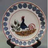 Llanelly pottery cockerel plate with painted decoration within a sponged daisy head border,
