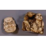 Japanese ivory netsuke of a seated man with two frogs, together with a carved ivory double headed